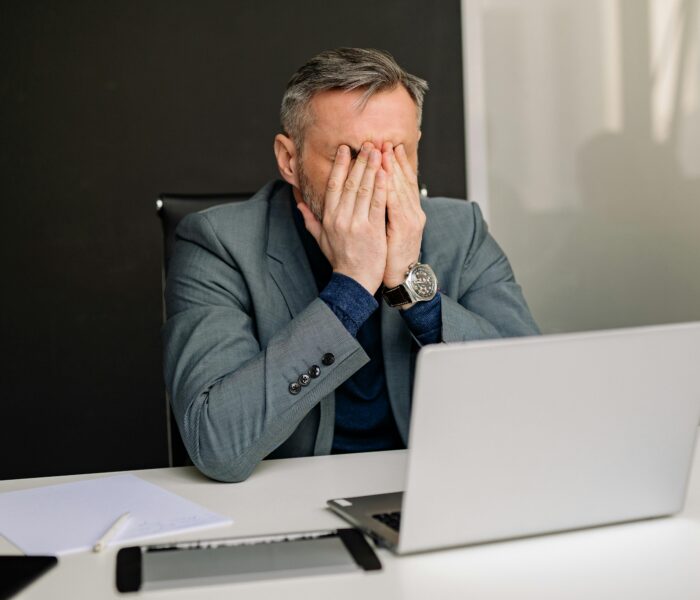 Small business owner stressed at desk frustrated with social media results that aren't generating leads