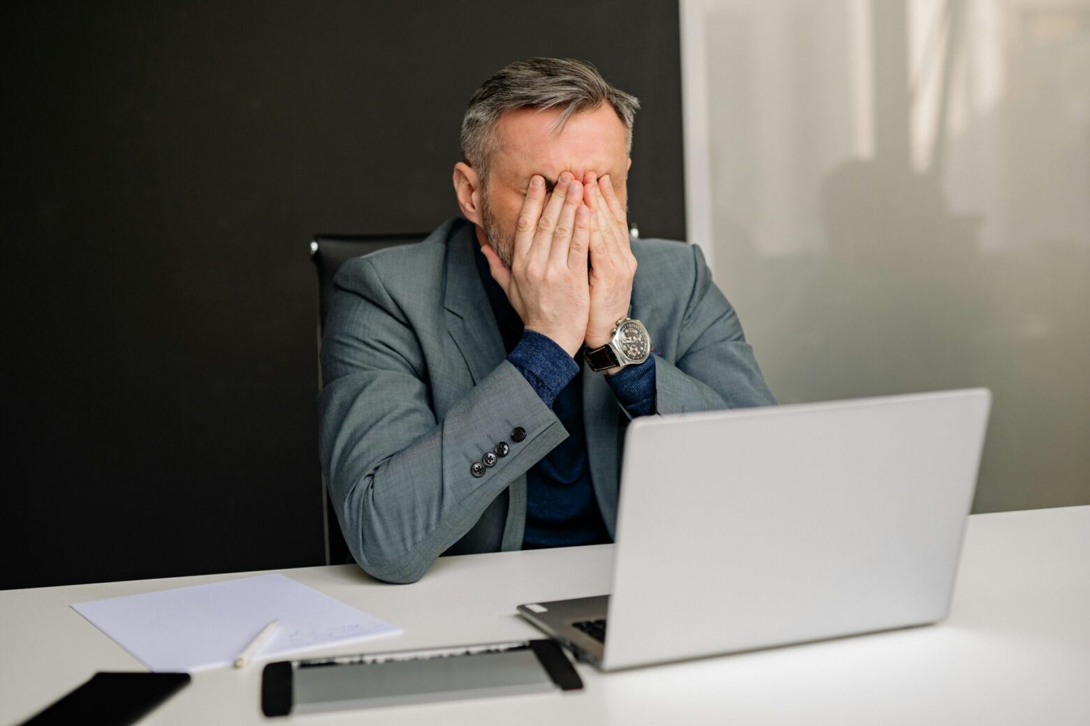 Small business owner stressed at desk frustrated with social media results that aren't generating leads